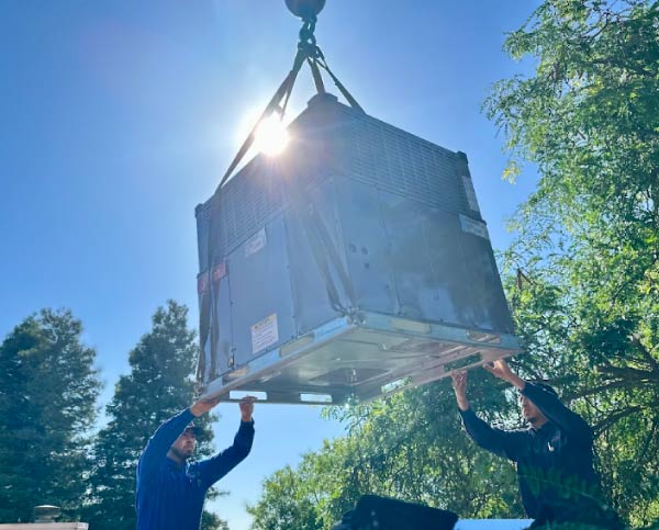 hvac company crew installing an ac unit with the sunshine on the background