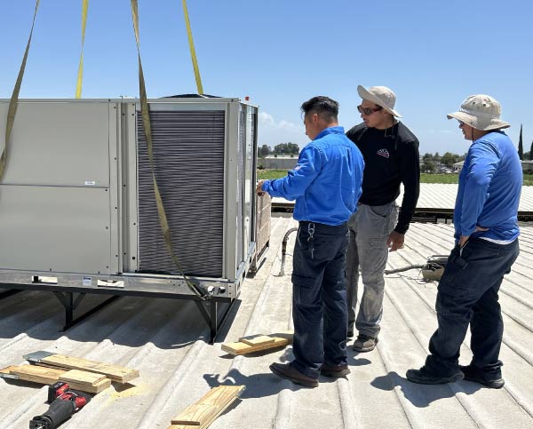 professional ac technicians installing a commercial ac unit