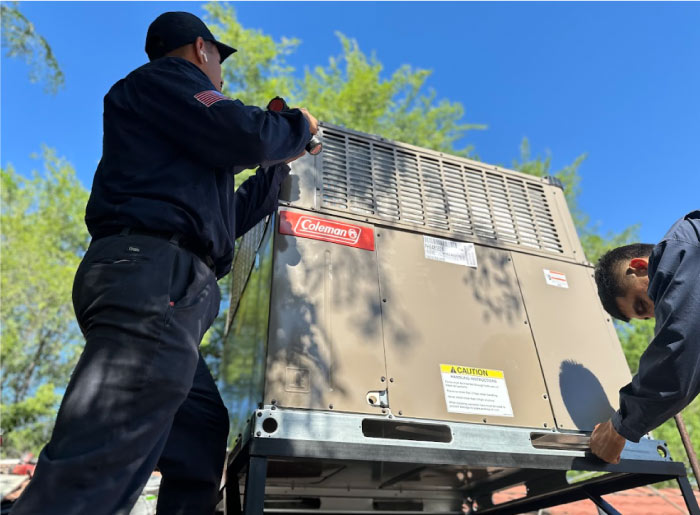 Expert commercial HVAC technician from Mechanical Air checking refrigerant lines on a large rooftop AC unit.