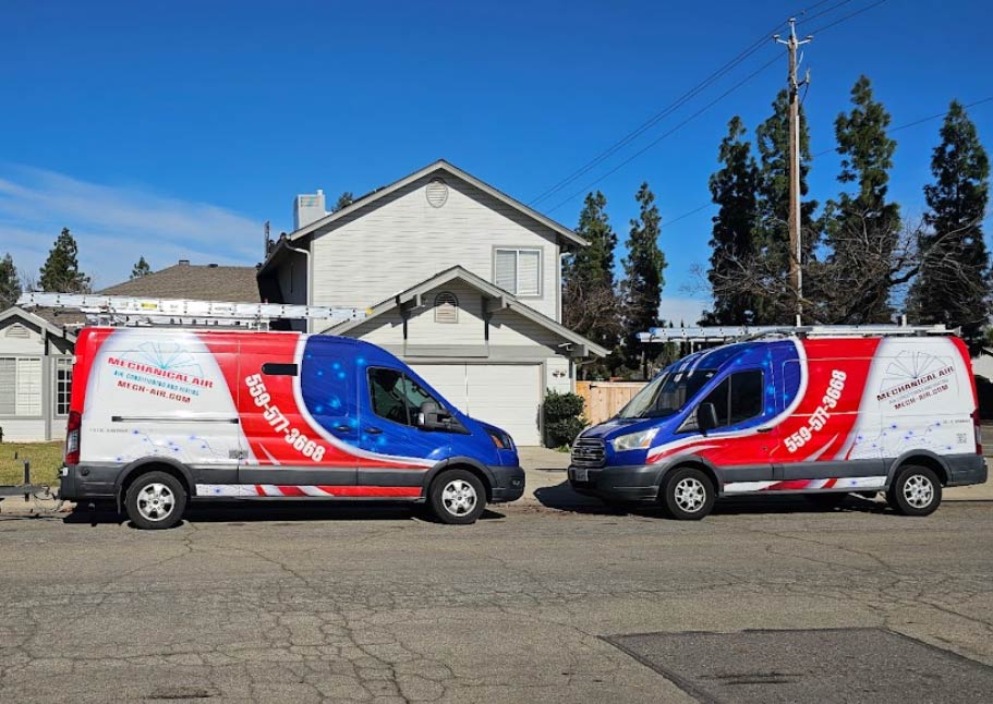 Two fully equipped Mechanical Air commercial service vans parked in a residential neighborhood, ready for emergency dispatch